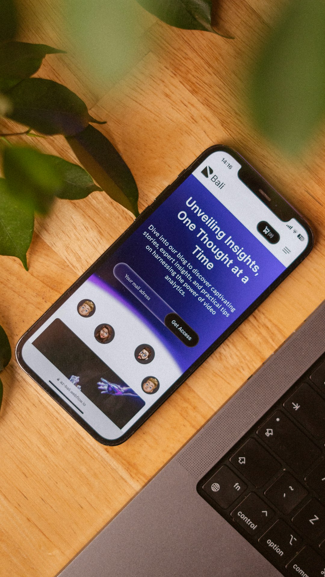 a-cell-phone-sitting-on-top-of-a-wooden-table-next-to-a-laptop-wcf-ysrgonu